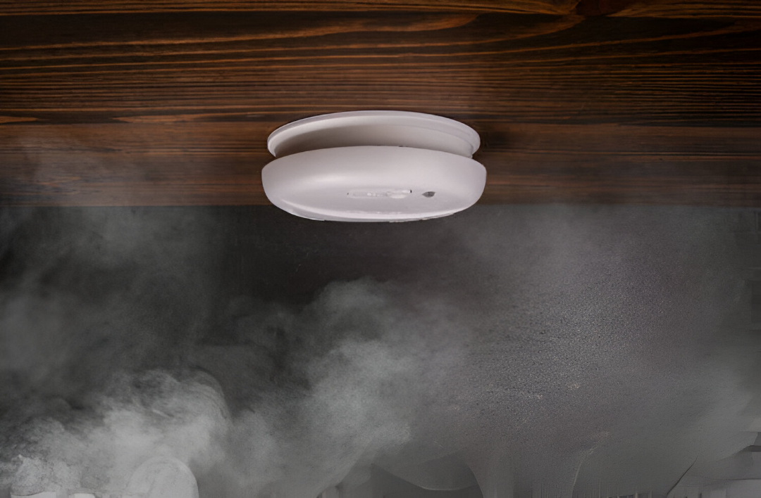 Electrician performing smoke alarm testing and safety checks in an Inner West home