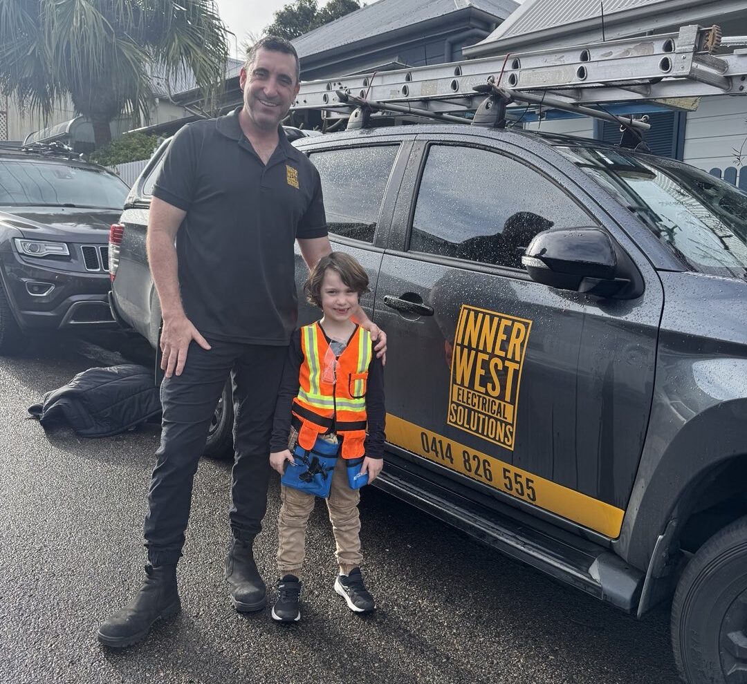 Chris and her sons in safety gear beside an Innerwest Electrical Solutions vehicle, highlighting family values.